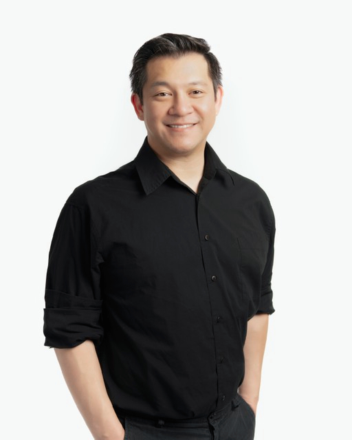 Bowie Medical Studio team member, Dr. Xavier Hsieh standing and posing while smiling in black casual attire